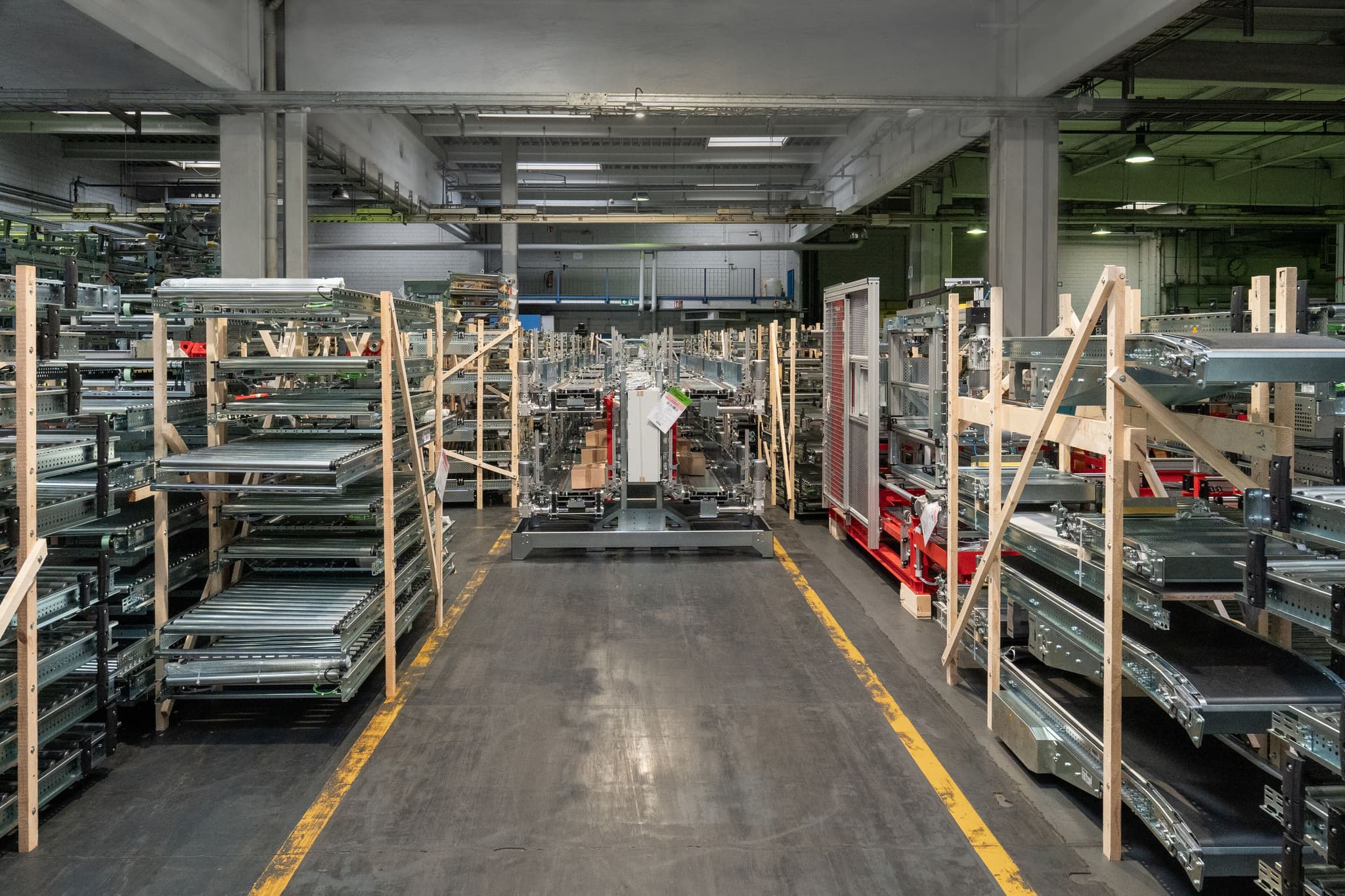 Montagehalle der MHS GmbH mit Förderanlagen und Rollenbahnen auf Transportgestellen aus Holz