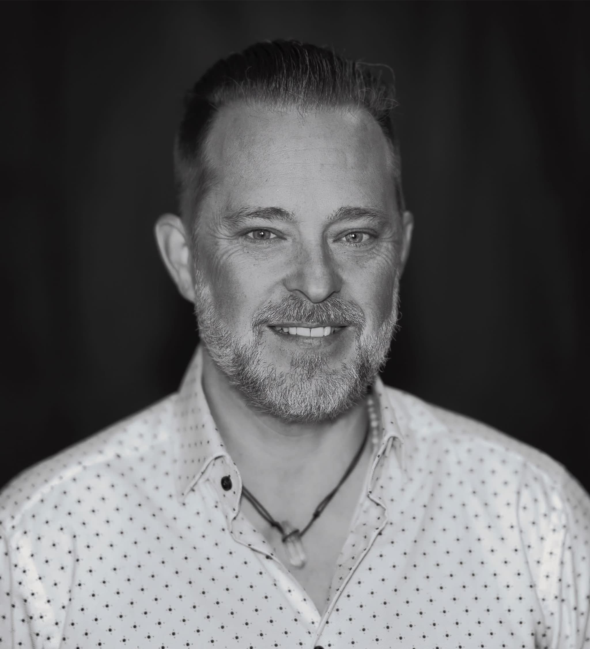 Schwarzweiss-Porträt von Brent Damkier, Vocal Coach bei TeamUnbesiegbar