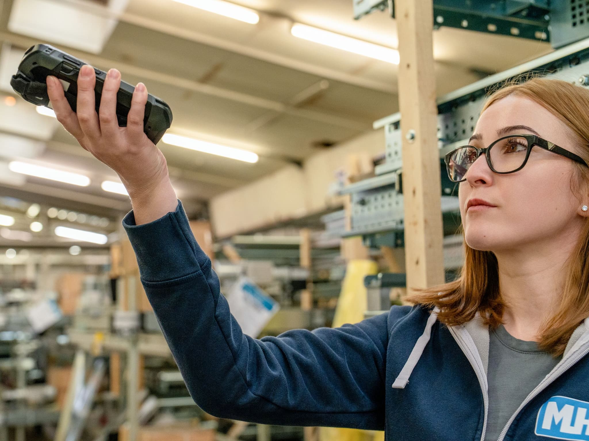 Mitarbeiterin der MHS GmbH erfasst Ware mit einem Handscanner im Lager
